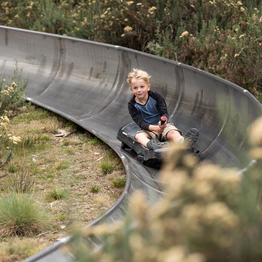 Boy riding down the bobsled